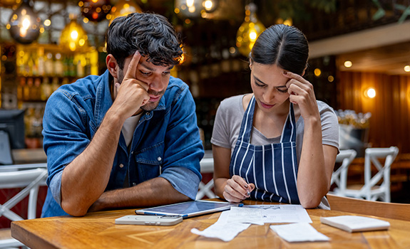 Business owner and waitress doing the accountancy at a restaurant